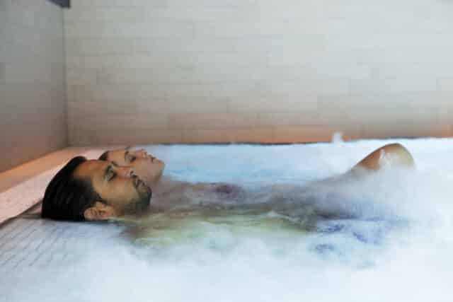 Paar entspannt im Wasser des Sprudelbeckens in der Therme Wien.