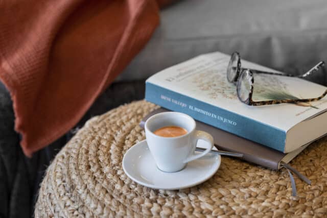 Espressotasse und Buecher auf einem Korbsessel in der Relax Lounge. Auf den Buechern liegt eine Lesebrille.