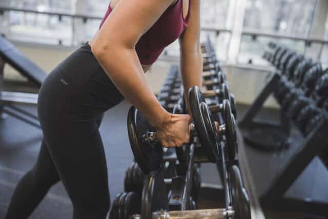 Frau trainiert mit freien Gewichten im Fitnessbereich der Therme Wien