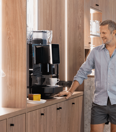 Mann laesst sich an der Kaffeemaschine in der Relax Launch einen Kaffee herunter.