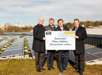 Vier Herren am Dach der Therme Wien. Im Hintergrund solarpaneele die am Dach montiert sind.