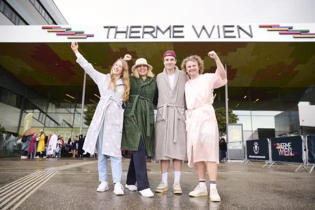 zwei Frauen und zwei Maenner posieren im Bademantel beim Bademanteltag der Therme Wien im Bademantel